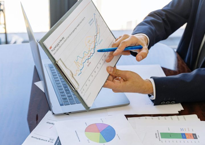 Free Business professionals discussing financial graphs and charts in an office setting. Stock Photo