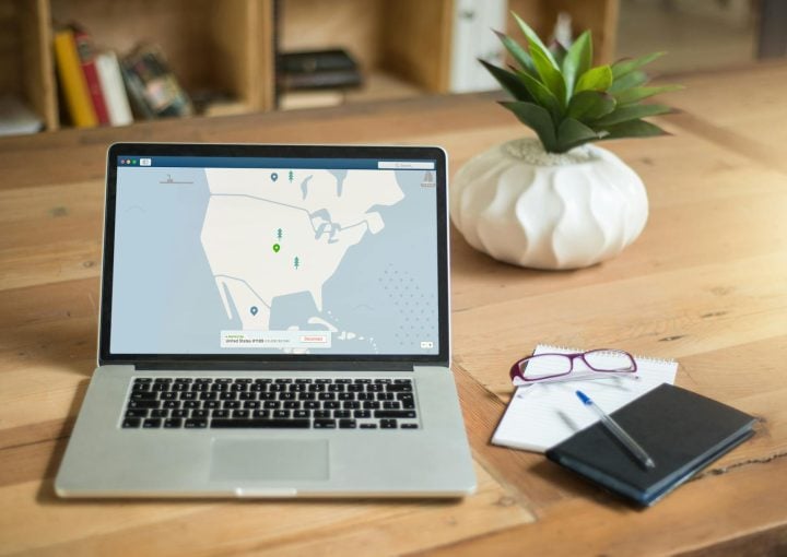 Laptop displaying a cybersecurity map on a wooden desk with a plant, notebook, and glasses, highlighting managed IT support and cybersecurity services by Host-It Ireland.